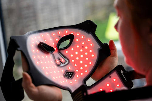SkinVitál Professional LED Light Therapy Mask glowing in red light mode